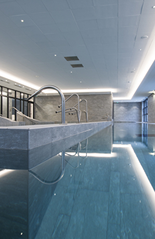 Une longue piscine intérieure, avec des lignes épurées et un éclairage doux, invitant à la détente et à la natation.