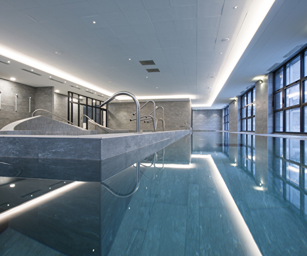 Une longue piscine intérieure, avec des lignes épurées et un éclairage doux, invitant à la détente et à la natation.