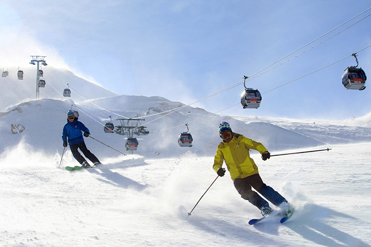 Personnes effectuant une descente à ski en montagne l'hiver