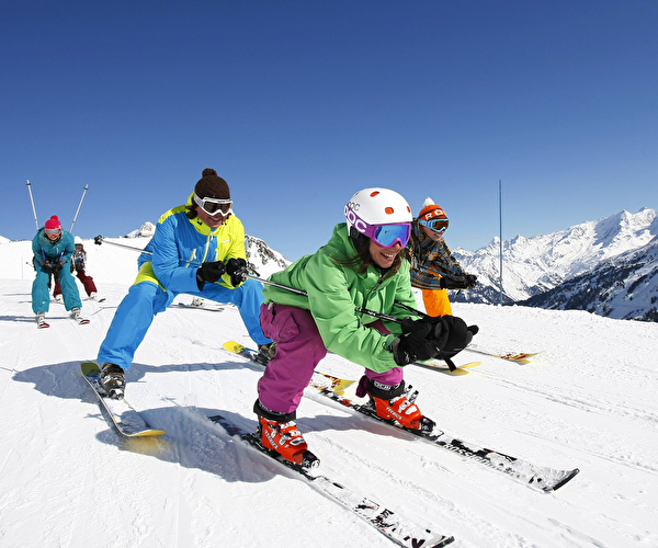 Groupe de skieurs effectuant une descente tout schuss sur une piste de ski enneigée
