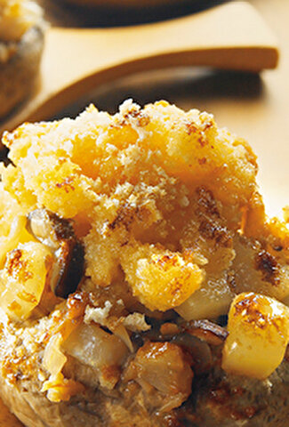 Crumble au beaufort présenté dans une cuillère en bois avec une feuille de salade
