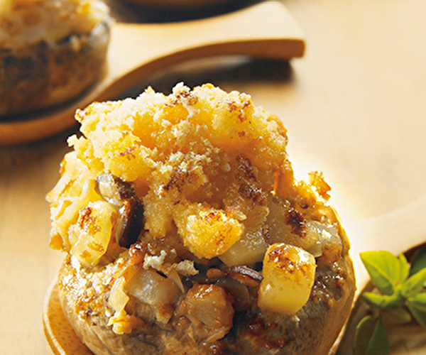 Crumble au beaufort présenté dans une cuillère en bois avec une feuille de salade
