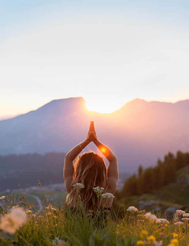 Personne face à un coucher de soleil profitant du calme pour se ressourcer en montagne