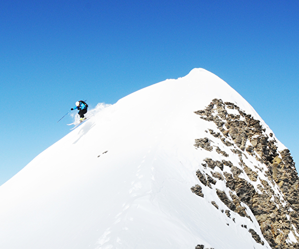 Skieur rider descendant le sommet d'une montagne enneigée en hors-piste l'hiver