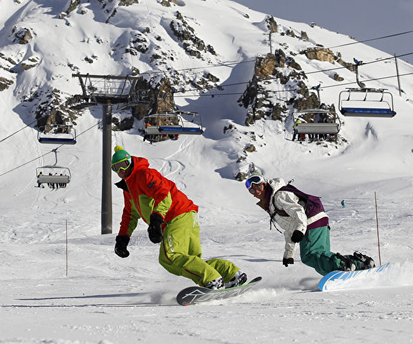 Personnes effectuant une descente en snowboard sur une piste en montagne l'hiver
