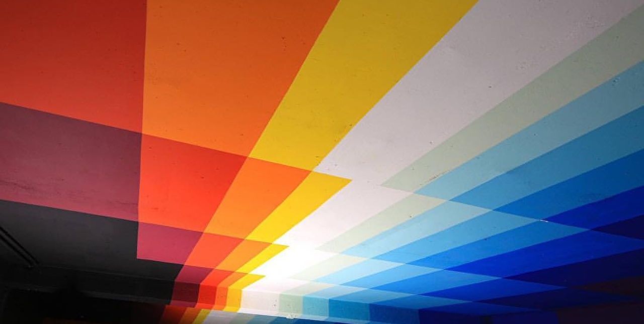 Plafond d'un parking souterrain peint et oeuvre artistique à base de couleurs vives allant du bordeaux au bleu nuit