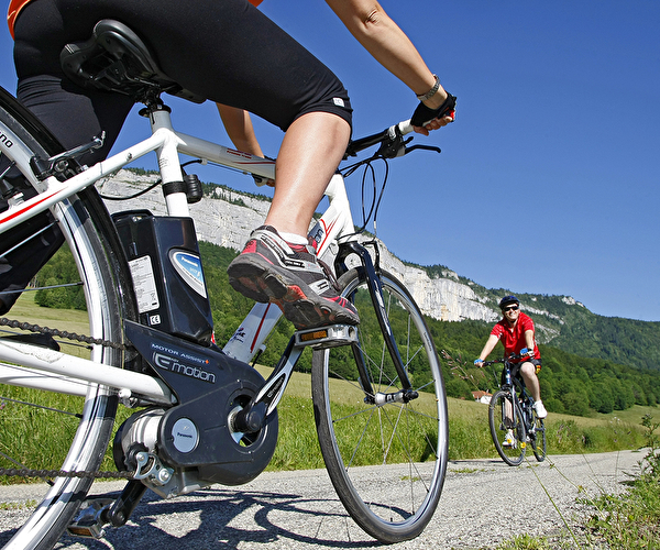Gros plan sur un vélo à assistance électrique mené par un sportif en montagne l'été