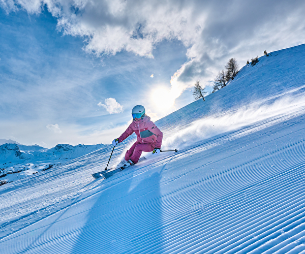 Personne effectuant une descente à ski et laissant ses premières traces sur la piste ensoleillée