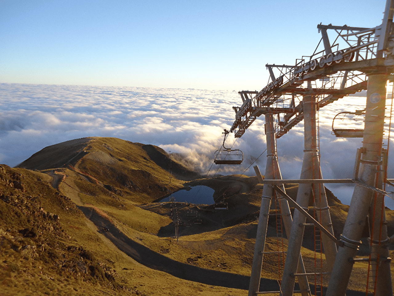 Vue sur un télésiège positionné en montagne l'été au dessus des nuages