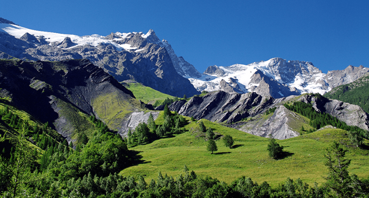 Vue panoramique sur les pics et sommets enneigés mais aussi sur les vallées verdoyantes en montagne