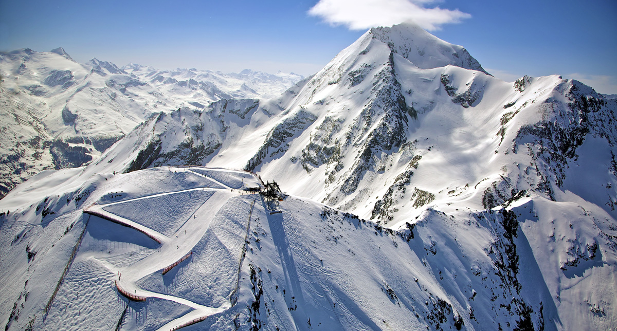 Panorama exceptionnel en montagne où se dessine une piste de ski de descente balisée en son milieu