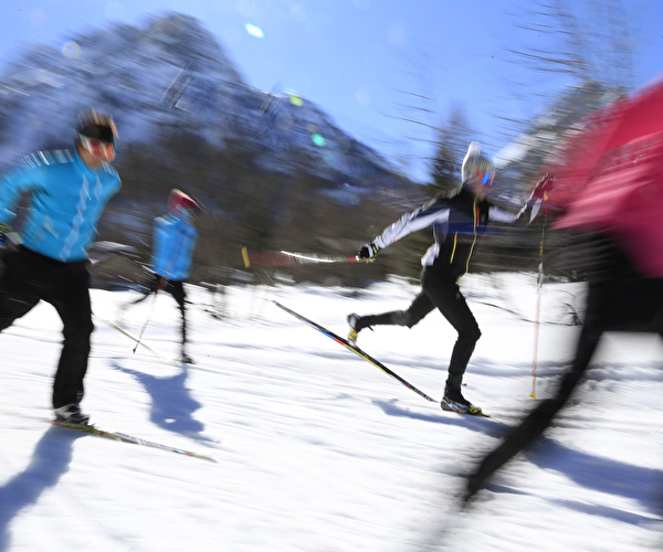 Personnes s'exerçant au skating ou ski de patinage sur la neige en montagne l'hiver