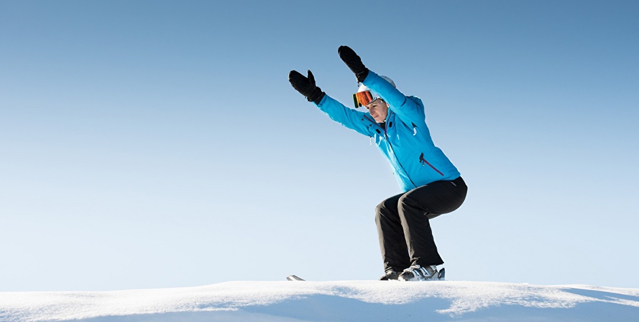 Personne effectuant des postures de yoga en montagne dans la neige