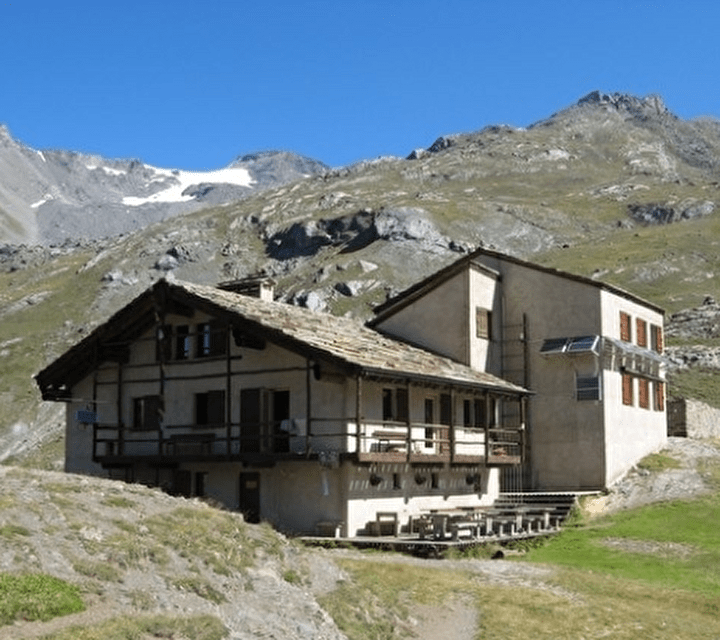 Vue sur un refuge de montagne entouré de verdure l'été