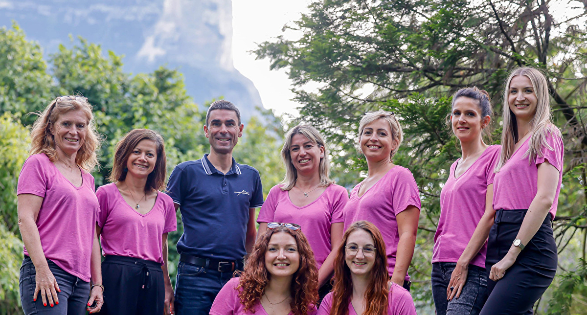 L'équipe France Montagnes, composée de personnes en chemises roses, pose ensemble avec enthousiasme.