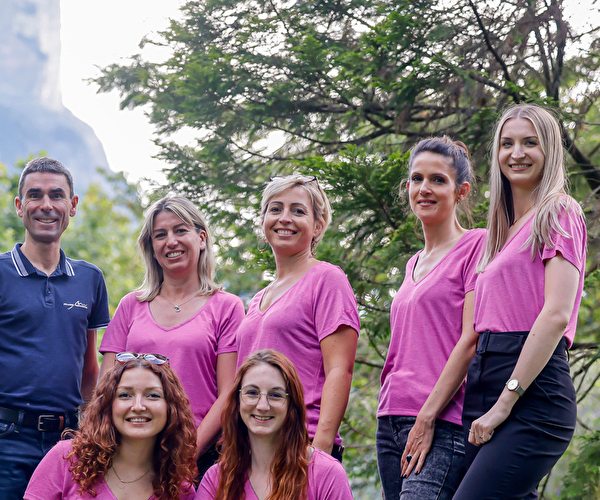 L'équipe France Montagnes, composée de personnes en chemises roses, pose ensemble avec enthousiasme.