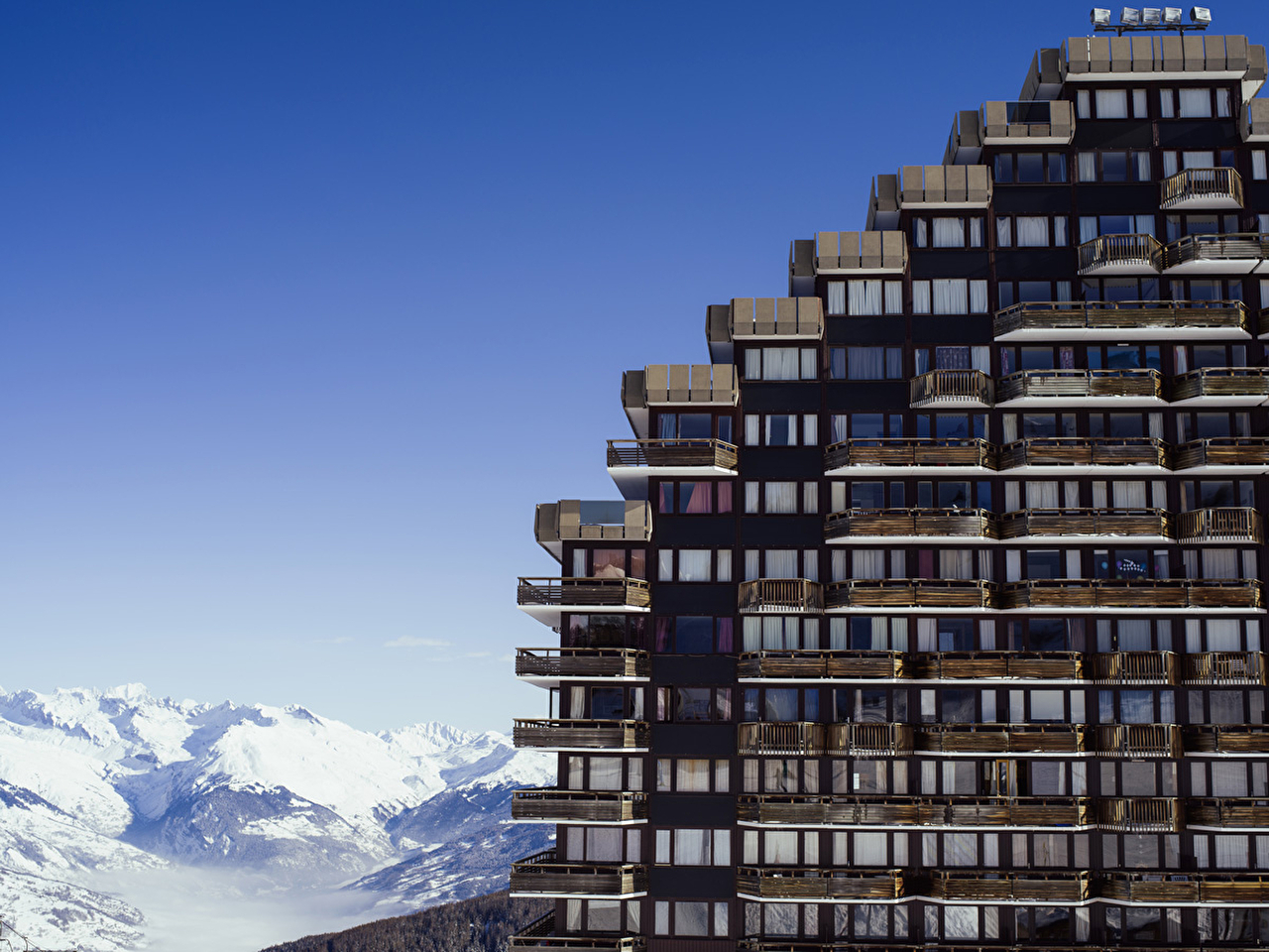 Vue sur une résidence de montagne avec étages face à la montagne blanche