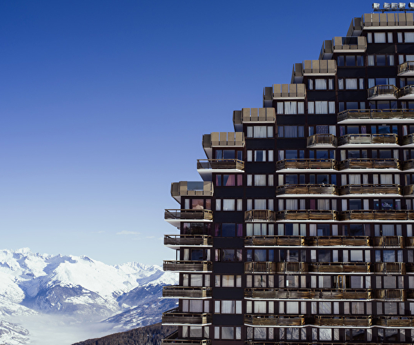 Vue sur une résidence de montagne avec étages face à la montagne blanche