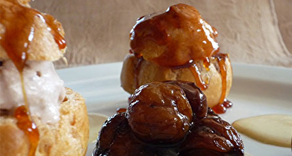 Présentation dans une assiette de profiteroles à la châtaigne avec sa crème anglaise