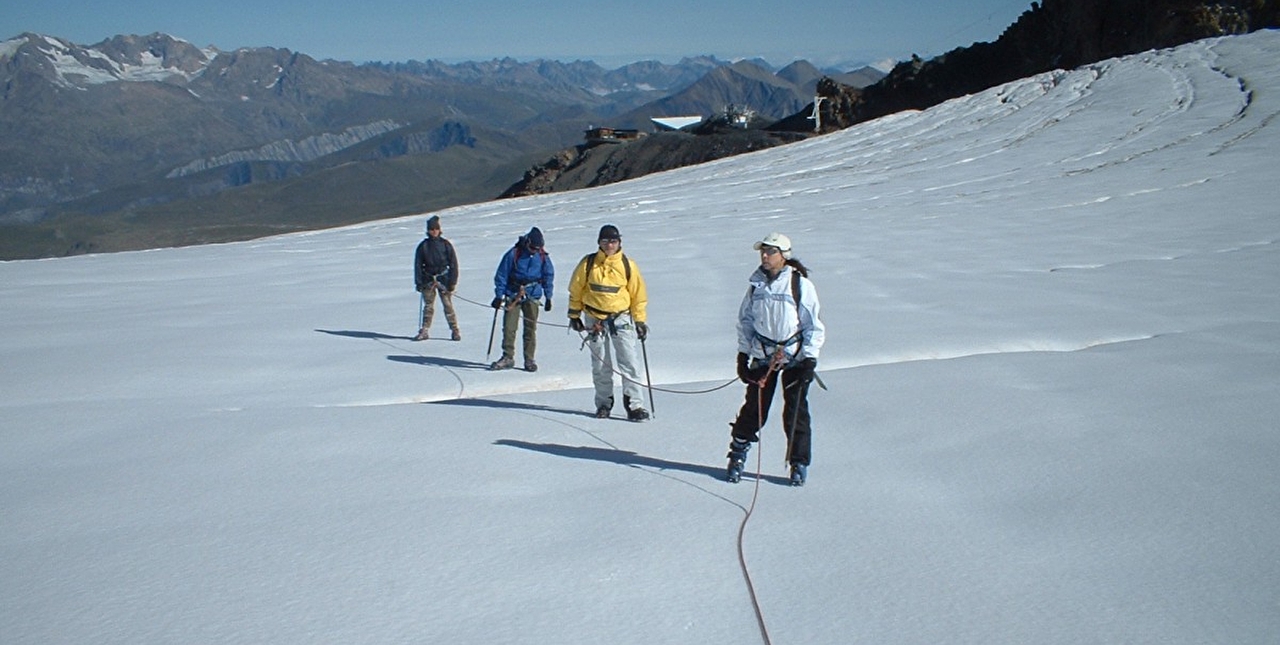Cordée de personnes effectuant une randonnée en montagne sur un glacier