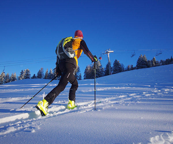 Personne effectuant une ascension en ski de rando dans la neige en montagne l'hiver
