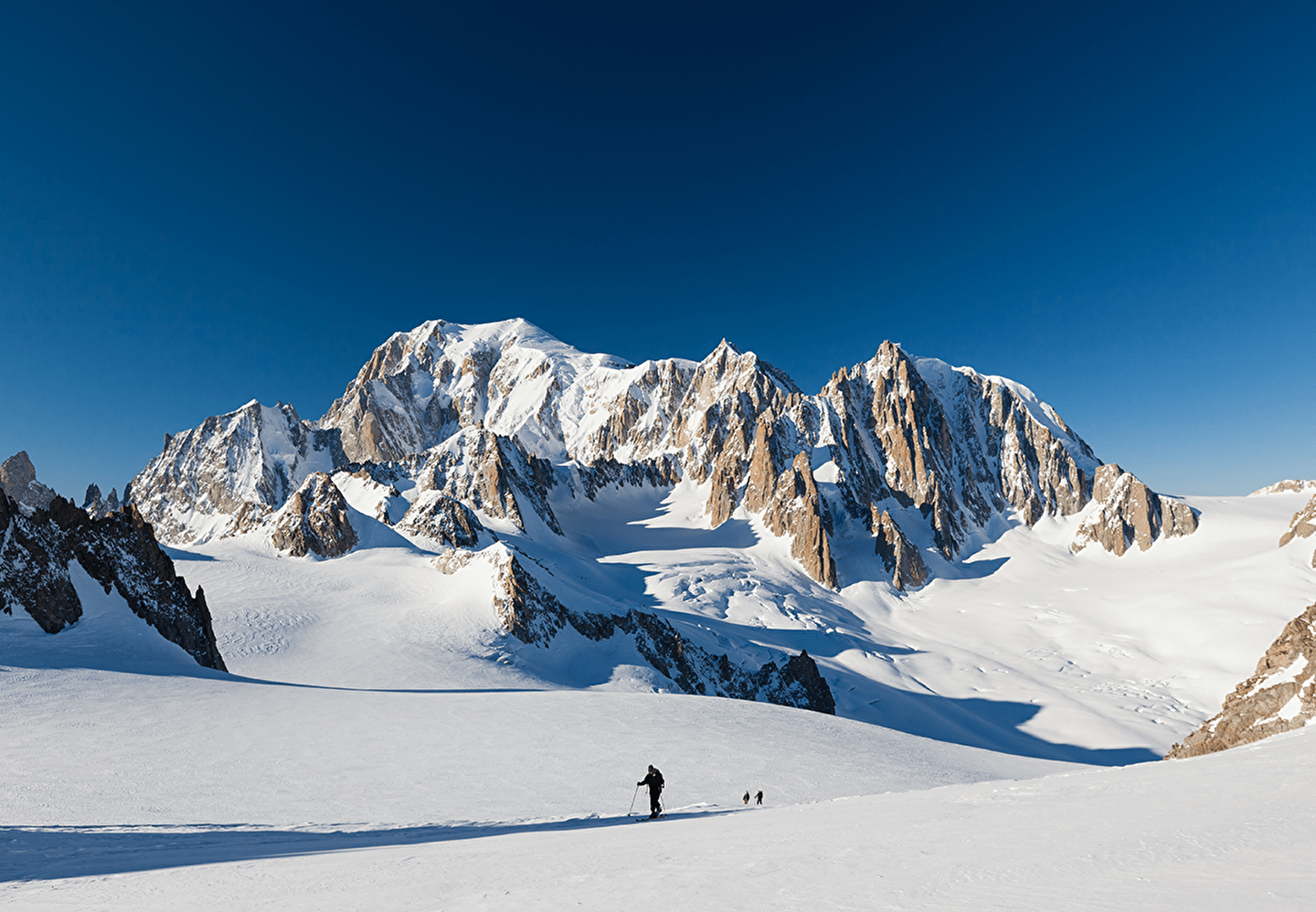Personne effectuant du ski de randonnée au milieu des montagnes enneigées