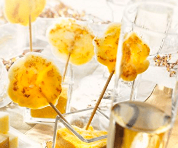 Beaufort présenté sous forme de sucettes plantées dans la polenta au milieu d'une table décorée