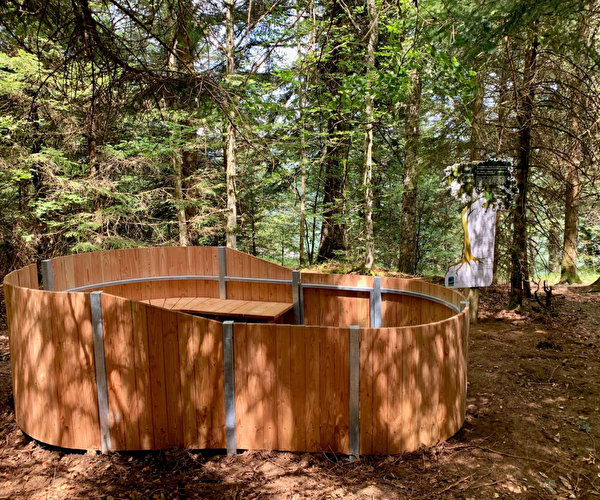 Vue sur un sylvatorium en bois en pleine forêts à travers les arbres