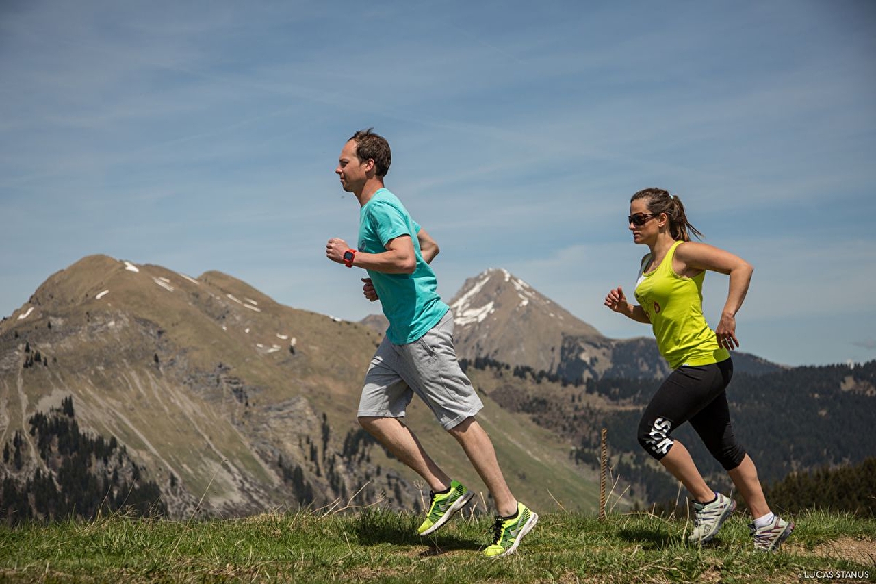 Duo de personnes effectuant une course trail en montagne l'été sous le soleil