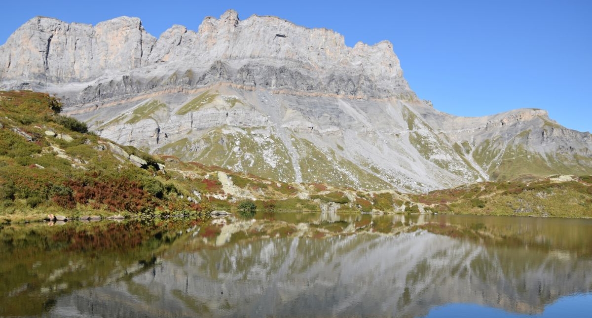 Vue sur un lac de montagne l'automne où les sommets se reflètent dans l'eau