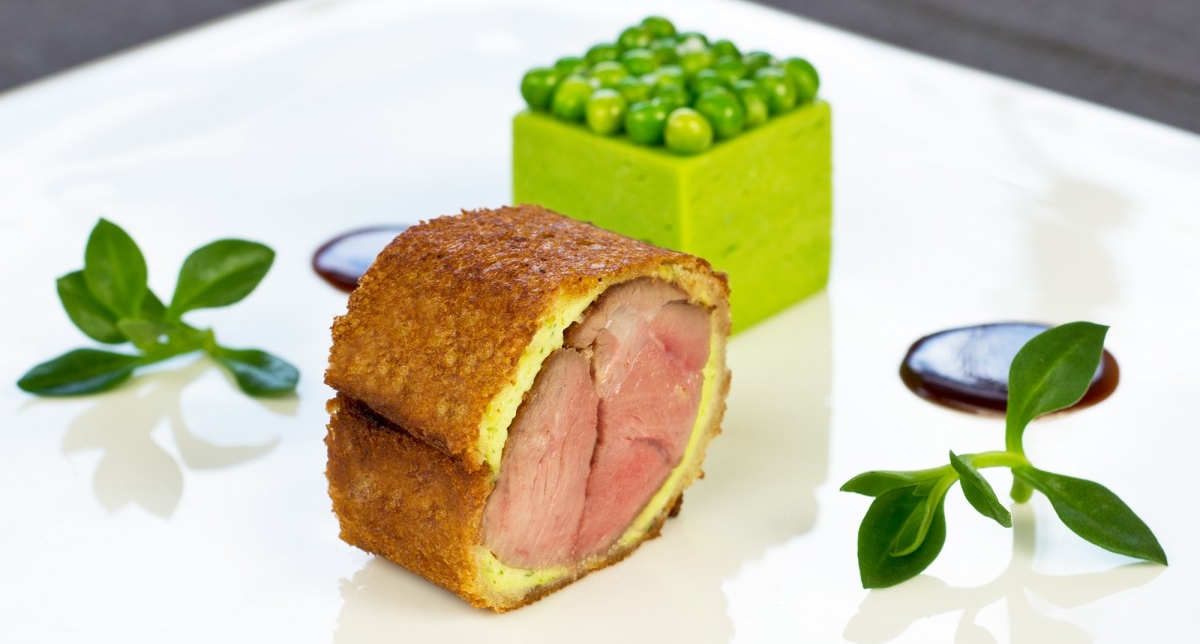 Assiette composée d'une recette gastronomique à base d'agneau et de petits pois