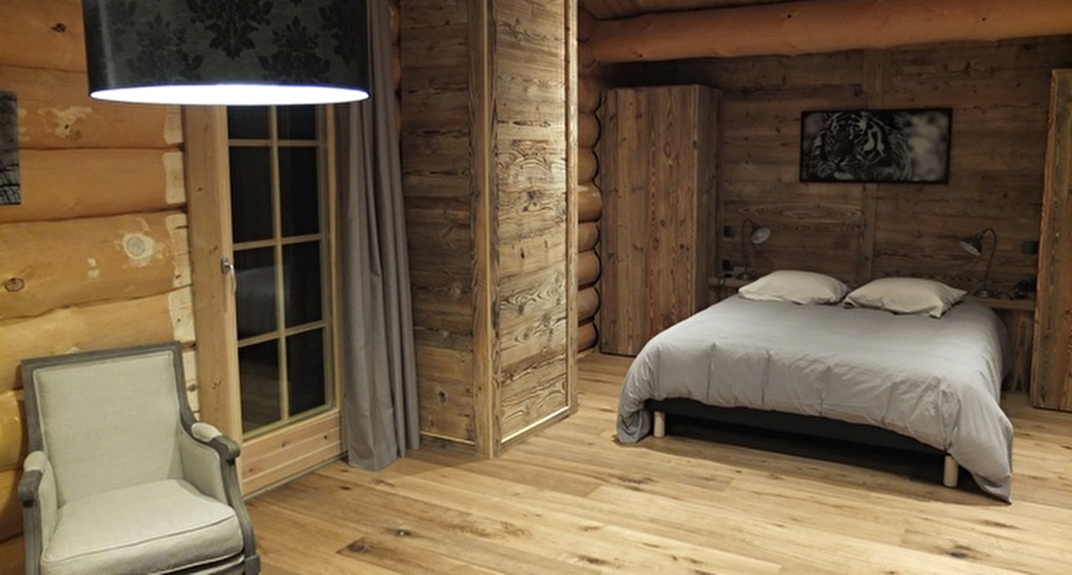Vue intérieure d'une chambre à coucher dans une fuste de bois avec lit double et espace détente