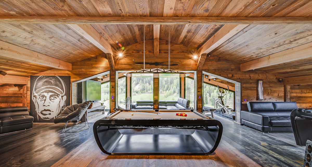 Vue intérieure du Chalet Quezac en bois et du salon proposant billard et meubles modernes