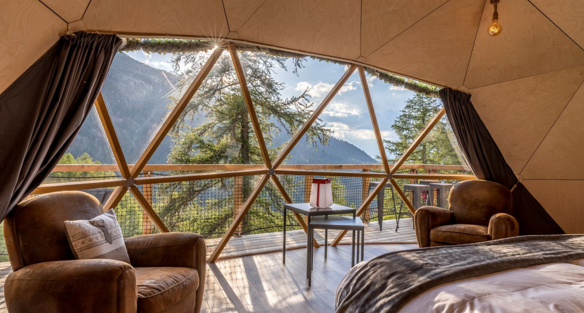 Vue intérieure d'une chambre sous dôme avec une vue insolite sur la nature environnante