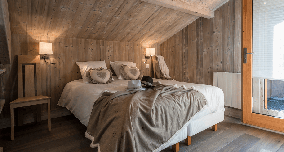 Vue intérieure d'une chambre à coucher cosy et lumineuse avec lit double et accès pour l'extérieur