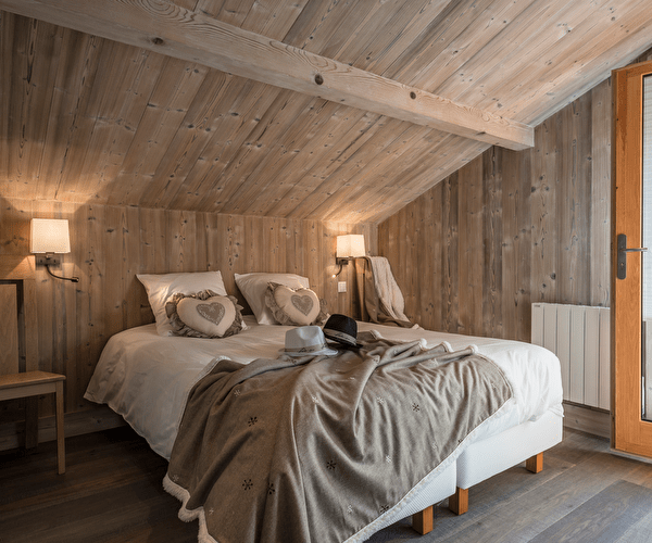 Vue intérieure d'une chambre à coucher cosy et lumineuse avec lit double et accès pour l'extérieur