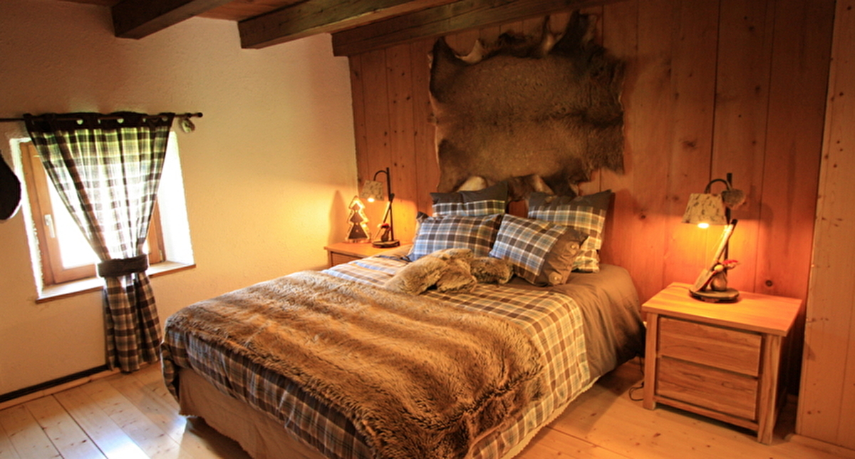 Vue sur l'intérieur d'une chambre à coucher avec lit double dans un chalet de bois
