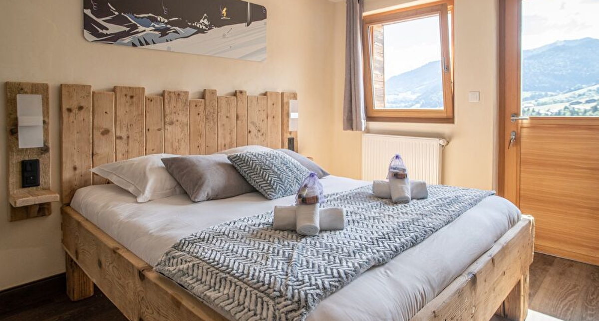 Vue intérieure d'une chambre à coucher avec lit double, vue sur la montagne