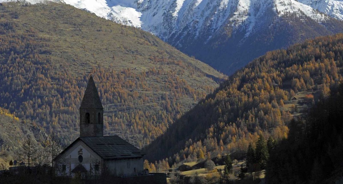 Eglise au coeur de la nature, entourée de vallées de sapins et montagnes enneigées