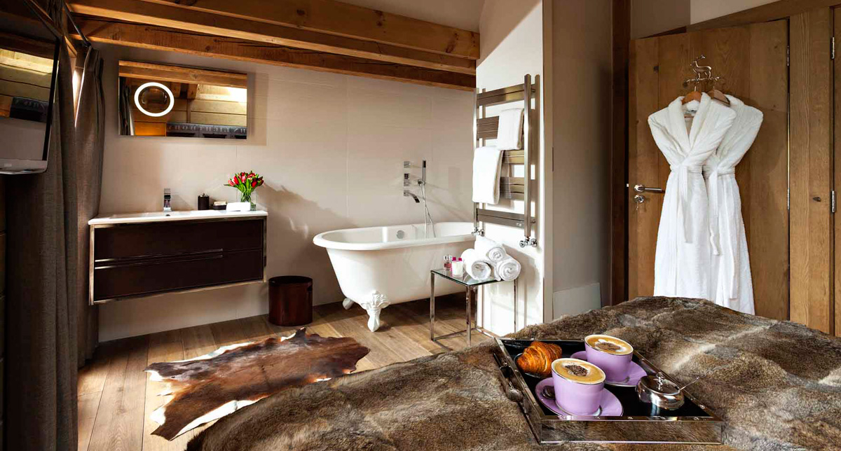 Vue sur une chambre à coucher avec salle de bain attenante proposant une baignoire à l'ancienne