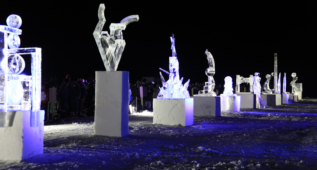 Sculptures de glace alignées sur des cubes et éclairées en pleine nuit