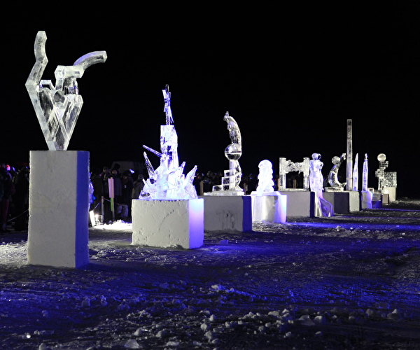 Sculptures de glace alignées sur des cubes et éclairées en pleine nuit