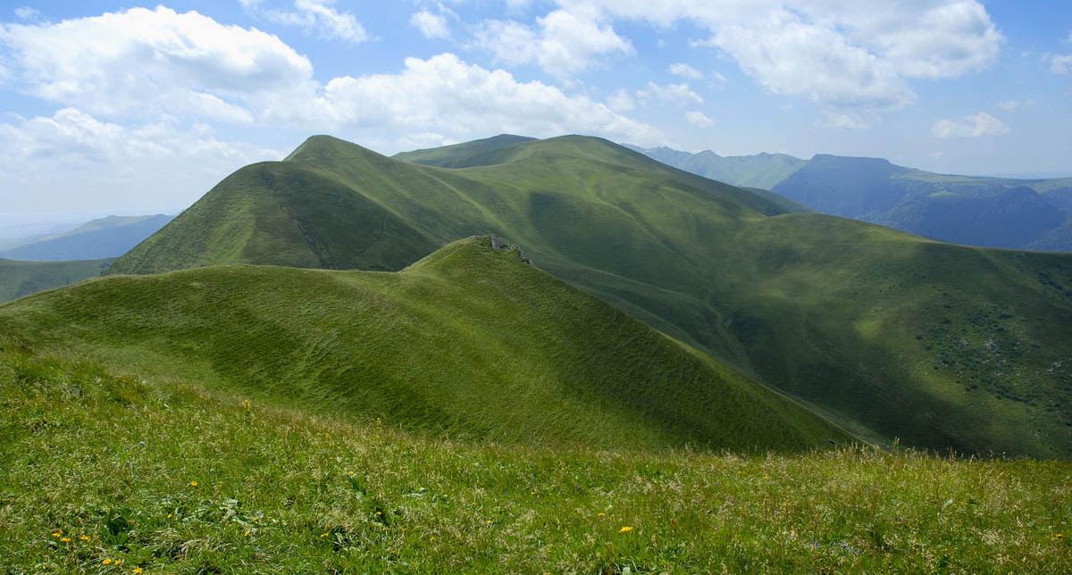 Vue sur les montagnes verdoyantes sous un ciel partiellement nuageux