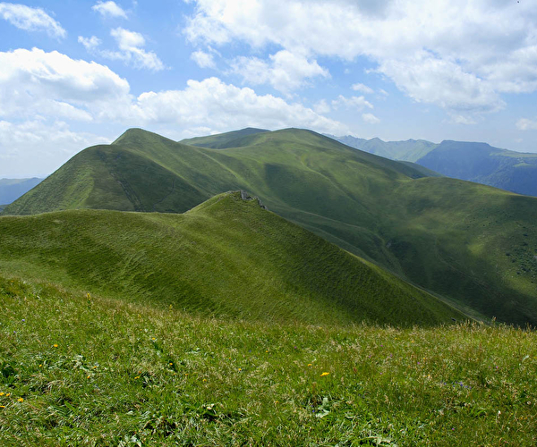 Vue sur les montagnes verdoyantes sous un ciel partiellement nuageux