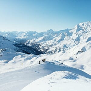 Point de vue sur les montagnes enneigées avec skieur en haut des pistes